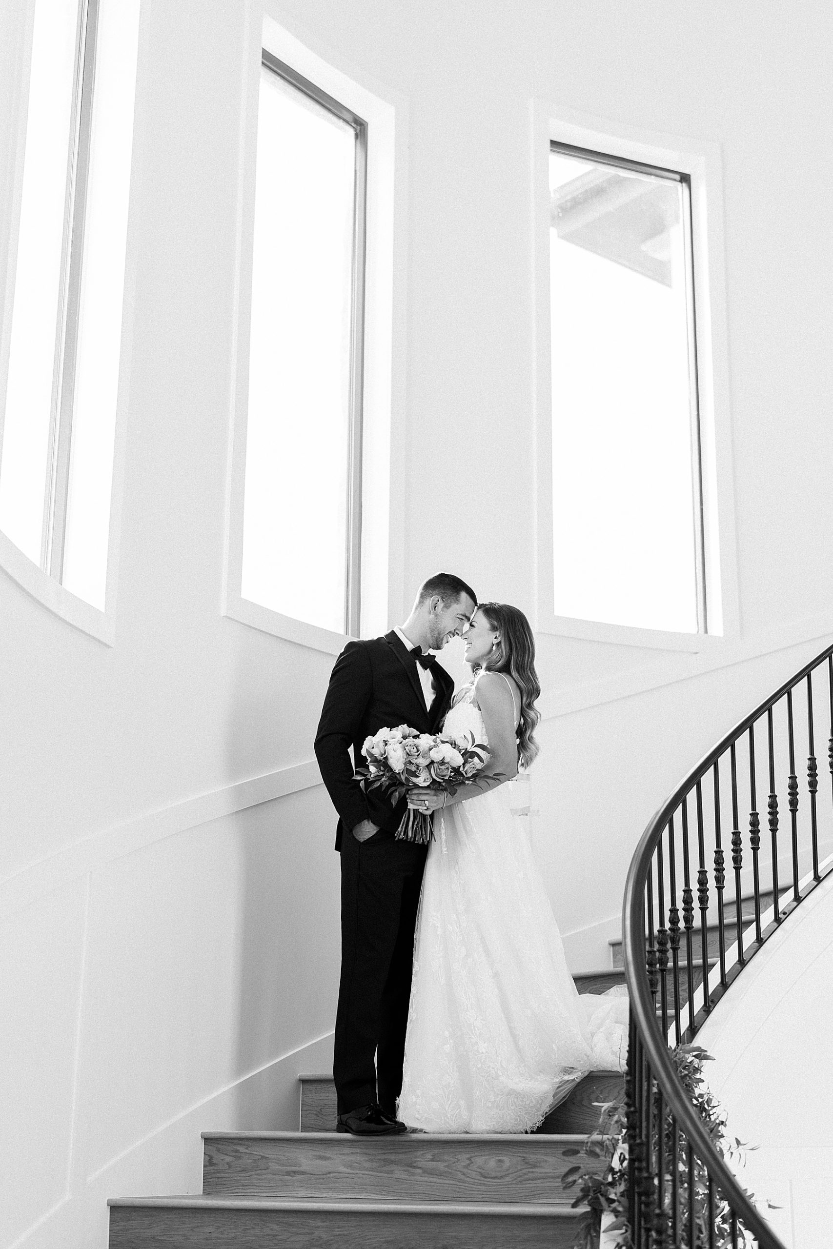 Black and white photo of couple on grand staircase | Reiley and Rose | Central Texas Wedding Floral Designer | The Preserve at Canyon Lake Wedding Venue | classic wedding inspiration, chic wedding, pink wedding color scheme | via reileyandrose.com