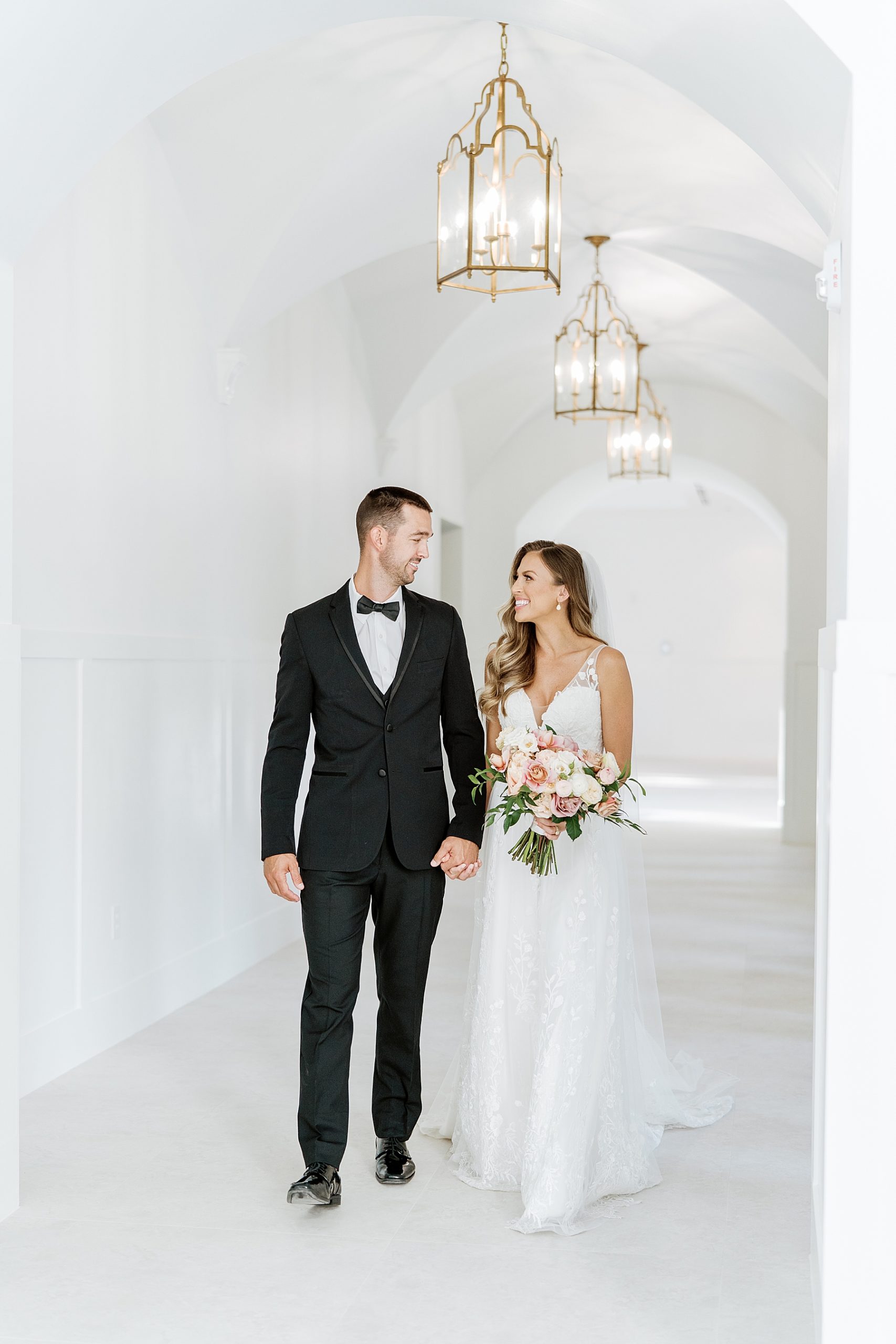 Couple walk together down hallway after ceremony | Reiley and Rose | Central Texas Wedding Floral Designer | The Preserve at Canyon Lake Wedding Venue | classic wedding inspiration, chic wedding, pink wedding color scheme | via reileyandrose.com