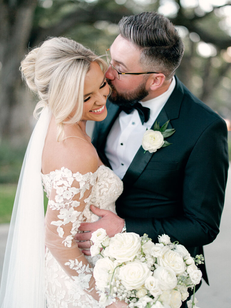 groom kissing bride on check  | Chandelier of Gruene Wedding | Modern Black and White Chic Wedding | 