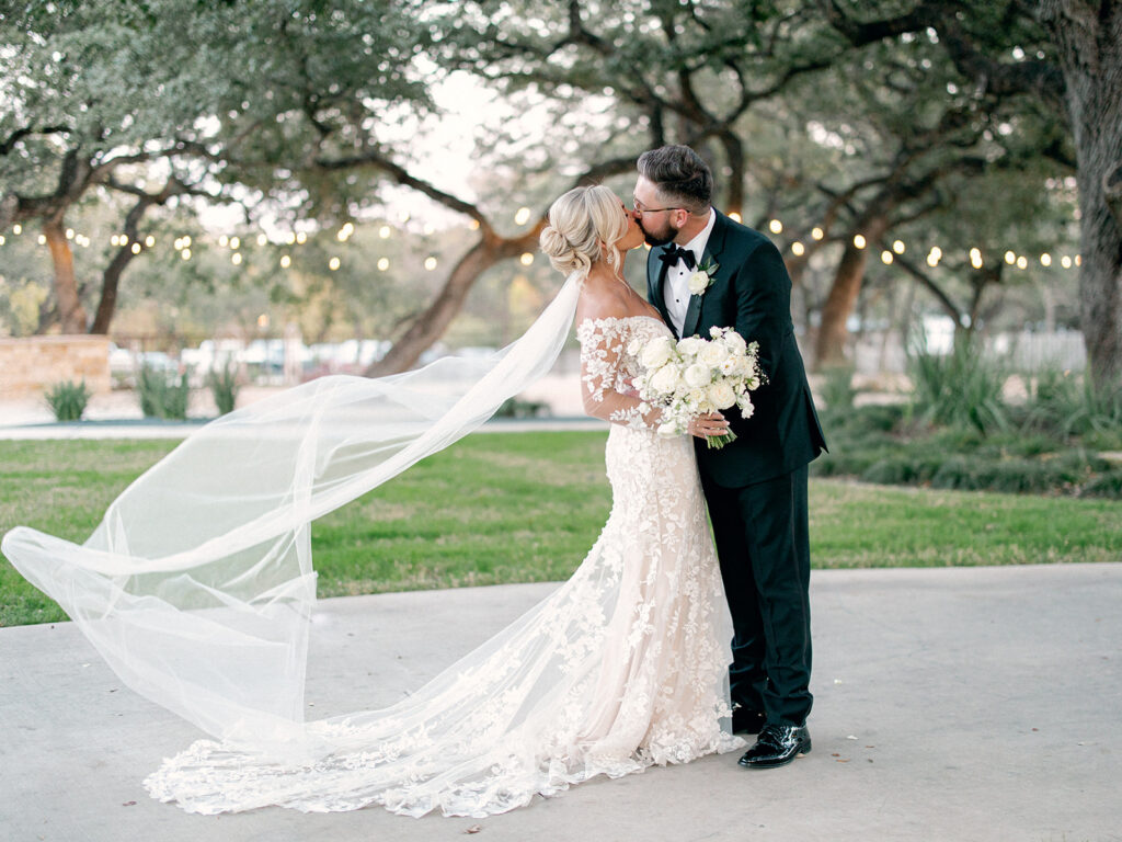 bride and groom with long bridal veil | Chandelier of Gruene Wedding | Modern Black and White Chic Wedding | 
