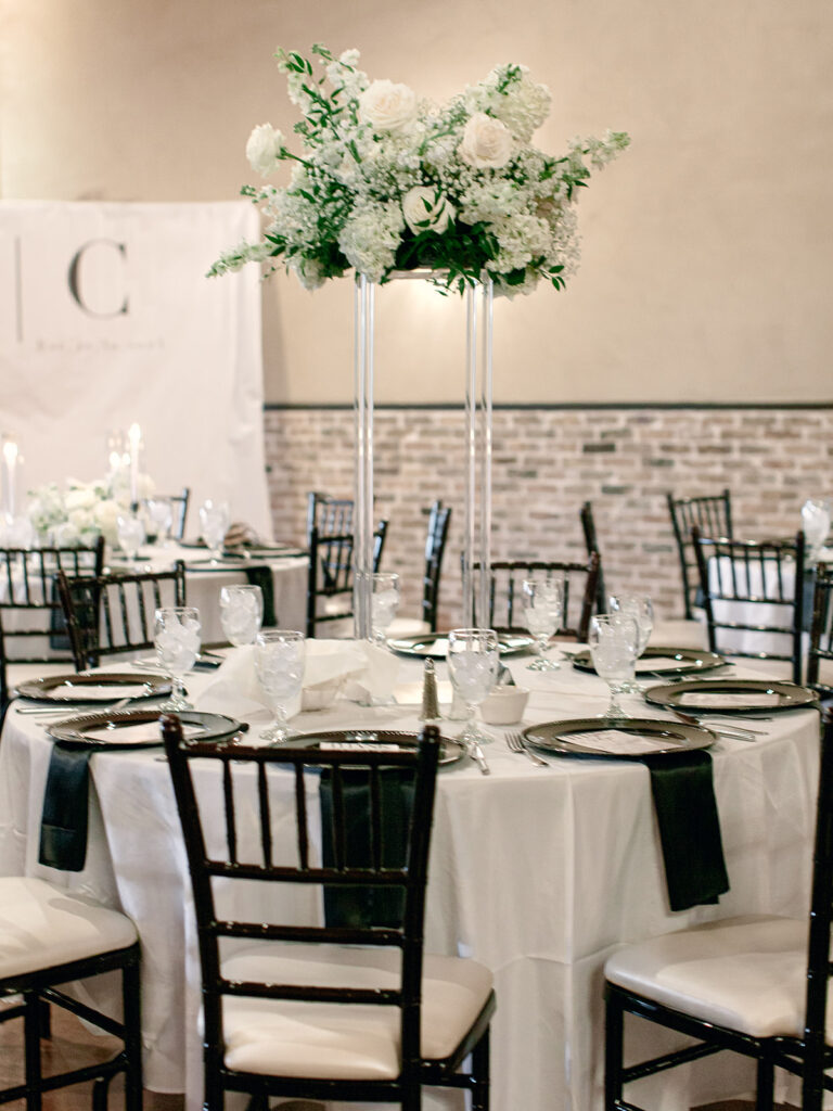 tall centerpiece on round table | Chandelier of Gruene Wedding | Modern Black and White Chic Wedding | 

