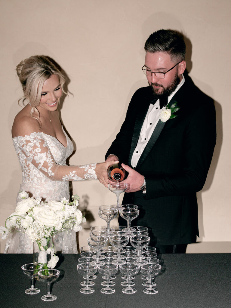 bride and groom pouring chapagne tower | Chandelier of Gruene Wedding | Modern Black and White Chic Wedding | 