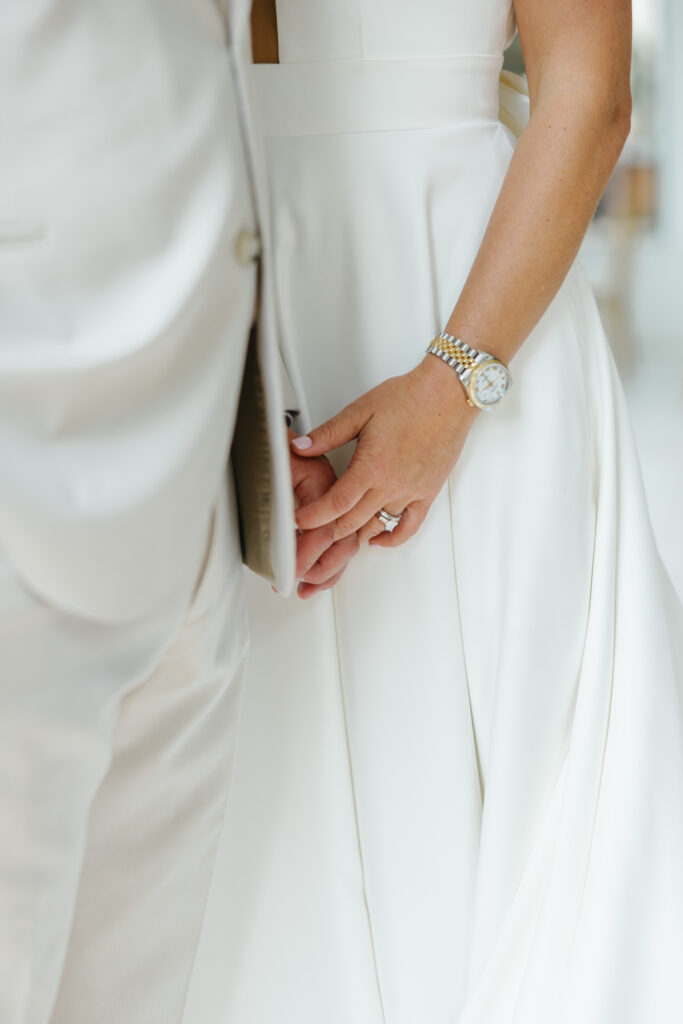 bride and groom holding hands ring and rolex watch shot
wedding planner