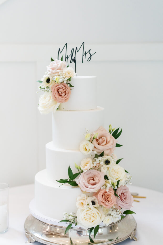 4 tiered white wedding cake with flowers
