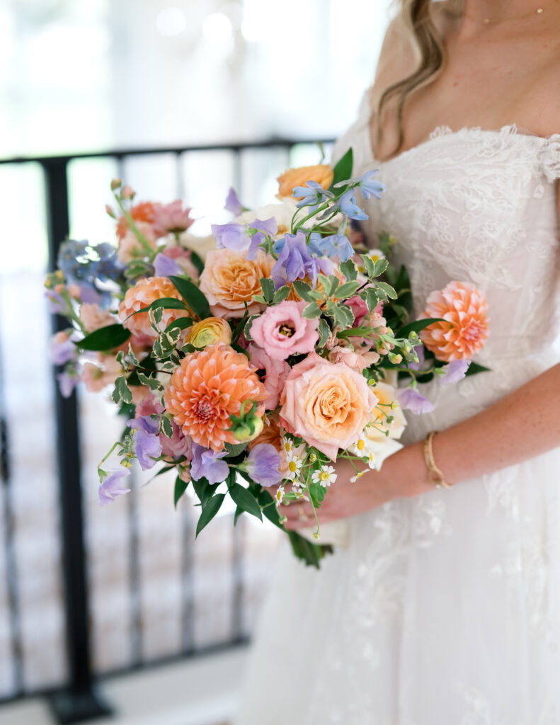 Lush bridal bouquet with peach, lavender, and blush blooms