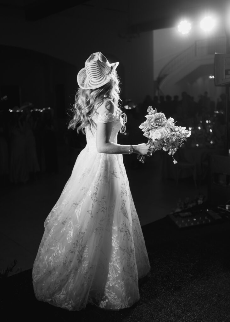 bride in cowboy hat tossing her bouquet