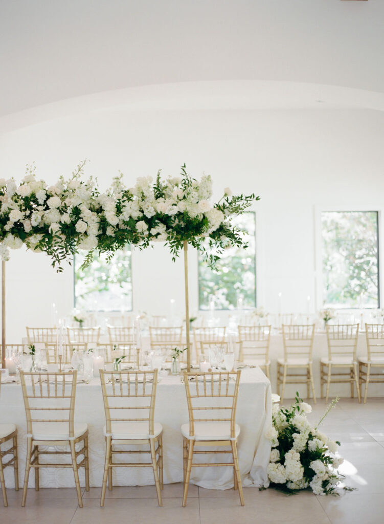 White and green head table wedding day flowers on gold stands elevated this reception beautifully