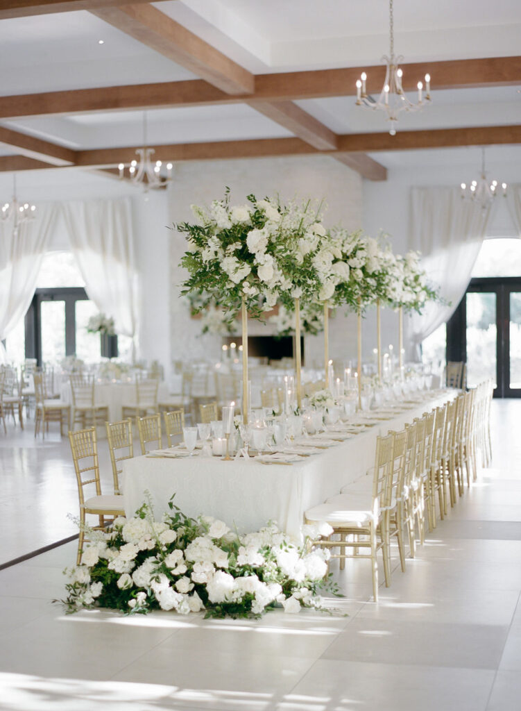 Tall white centerpieces on gold stands lined the head table
