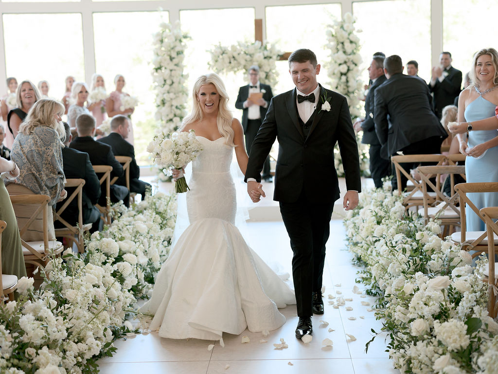 The newlyweds walking down their flower lined aisle just after being married!