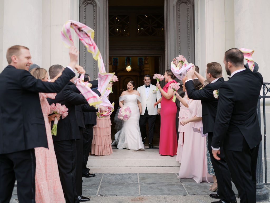 Newlyweds exiting church with their New Orleans wedding flowers