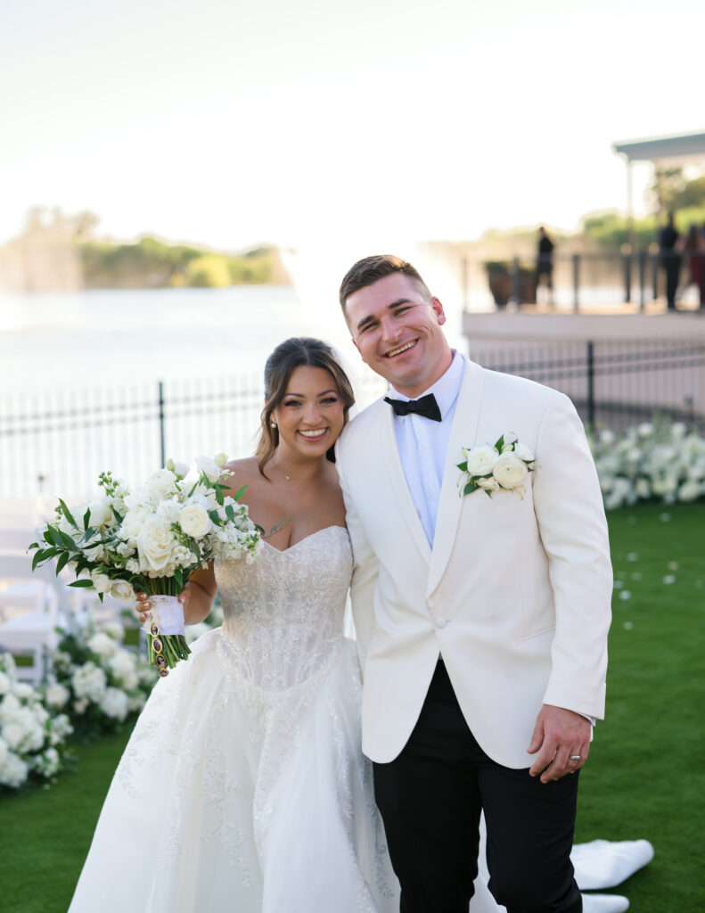 Newlyweds with their gorgeous white wedding flowers