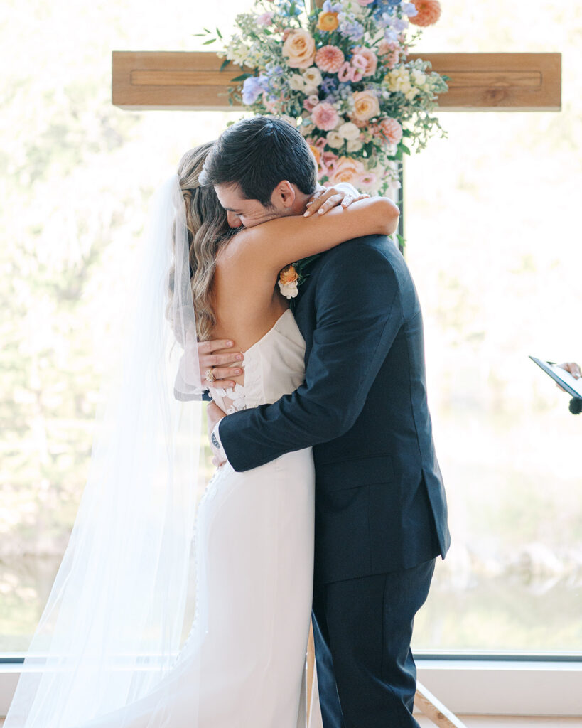 Newlyweds hugging at cross